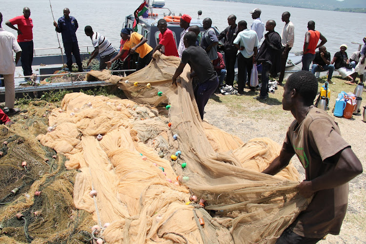 Kenya Coast Guard officers led by Lieutenant Bernard Mibei remove confiscated illegal fishing gear - undersized nets - at Homa Bay Pier Beach in Homa Bay on October 14.