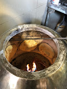 Naan bread baking in a tandoor.