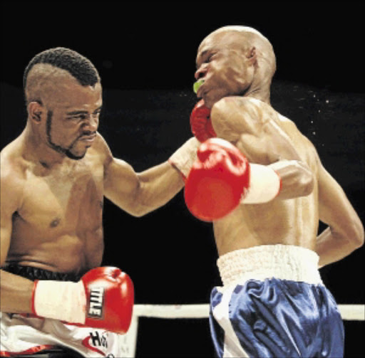 FULL STEAM: Ashley Dlamini, left, fights Vuyani Dosi in the junior featherweight division at Emperor's Palace in Ekurhuleni PHOTO: SYDNEY SESHIBEDi