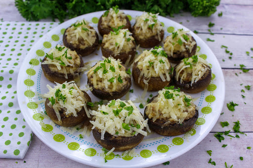 Chevre and sausage stuffed mushrooms on a plate.