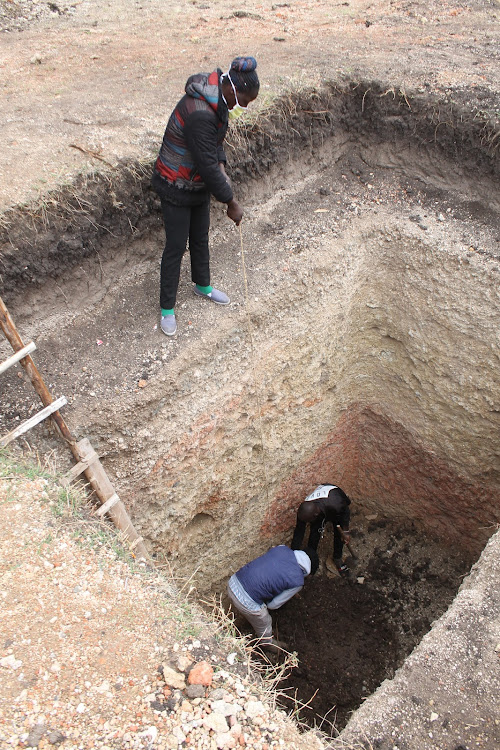 Methan Mbithi pulls soil from a pit latrine at Kinanie chief's camp in Athi River, Machakos county on September 15.