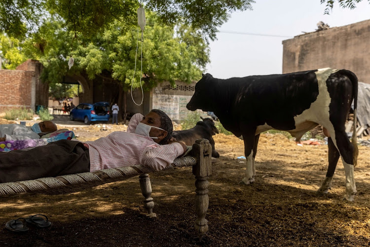 Roshan Lal, 48, rests in a cot while he receives treatment at a makeshift open-air clinic in Mewla Gopalgarh village.