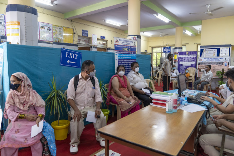 People wait at a Covid-19 vaccination centre in New Delhi, India, on June 21, 2021. Prime Minister Narendra Modi announced free vaccinations for all adults in a move prompted by criticism of his administration’s handling of India’s deadly second virus wave Picture: BLOOMBERG/SUMIT DAYAL