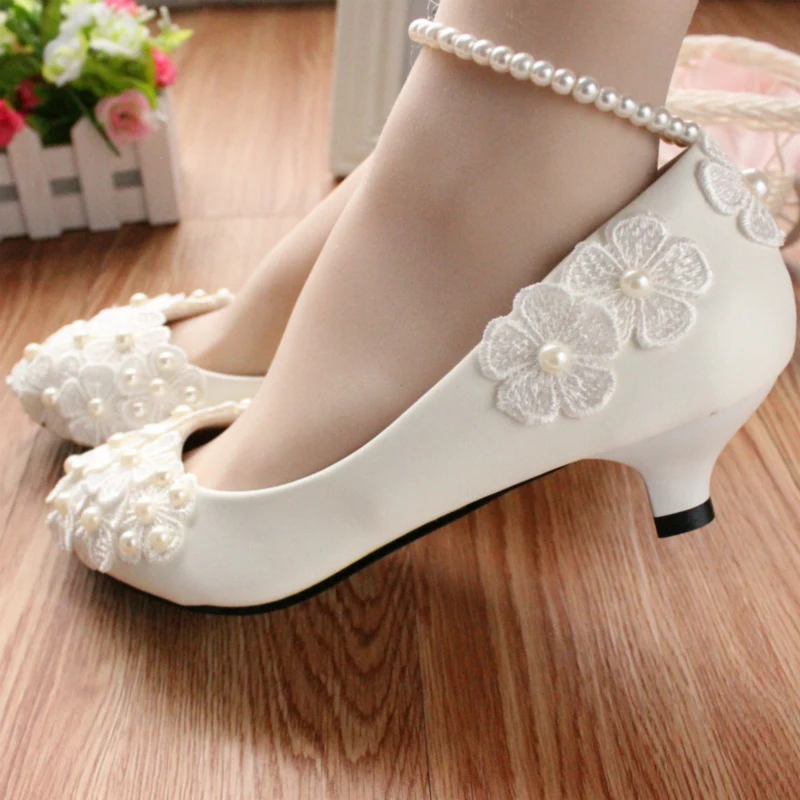 Witte parel enkelband bruidsschoenen. Elegantie voor je trouwdag. Stijlvolle schoenen met een parelketting voor een speciale look.