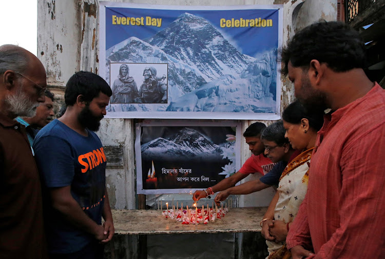 People light candles during a prayer service for those who died on Mount Everest during expeditions as they celebrate Everest Day in Kolkata, India