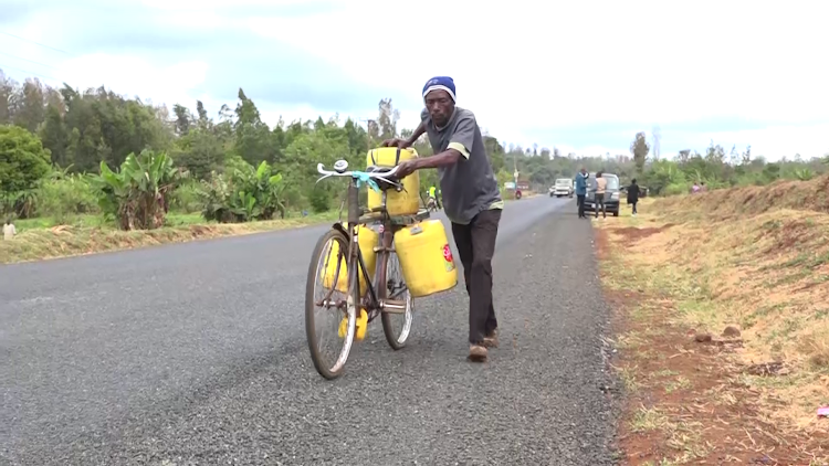 A resident of Kenol town in Maragua ferrying water from a stream on the Kenol-Murang'a road.