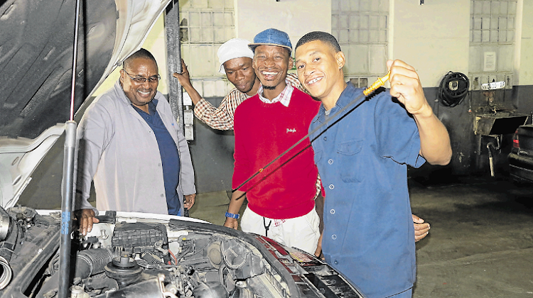 Former Buffalo City College lecturer Irna Makalima, left, quit his job of 14 years to open his own accredited automotive workshop to help some of his students gain the practical experience they need to qualify as auto mechanics. Eishiad Heslop, Sibonise Piet and Lizo Mzekeli have now blossomed into qualified auto mechanics after four years of training under Makalima’s tutelage