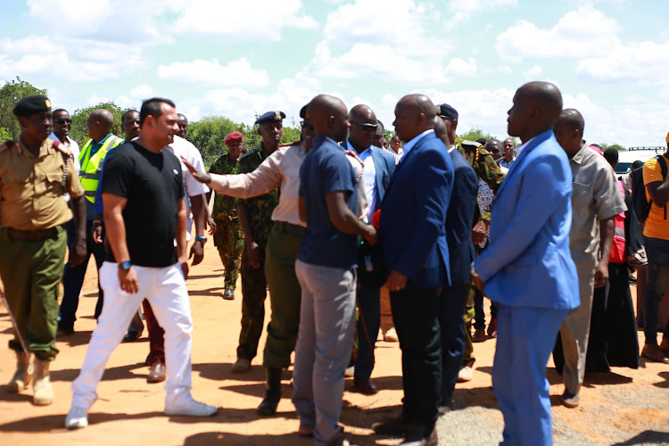 Cavin Omondi speaks with Interior CS Kithure Kindiki at Shakahola on Tuesday.