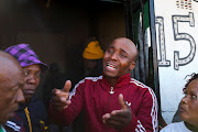 A man pleads with protesters after community members burned shacks and belongings as they searched for alleged illegal miners known as ‘zama-zamas’ as a protest, following alleged rape of eight models on July 28 when a television crew filmed a music video at a mine dump in the nearby township, in the West Rand, South Africa, August 8, 2022. 