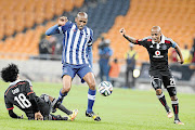 GROUNDED: Issa Sarr of Pirates goes down in an effort to stop Maritzburg United's Ashley Hartog during the Absa Premiership match at the FNB Stadium last night. Maritzburg won the game 2-1