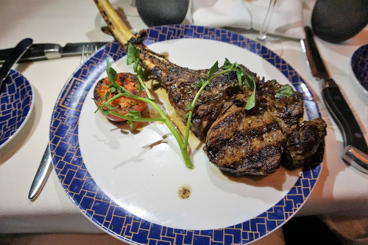 A bone-in Tomahawk rib eye steak entrée at Cagney’s Steakhouse on Norwegian Getaway. 