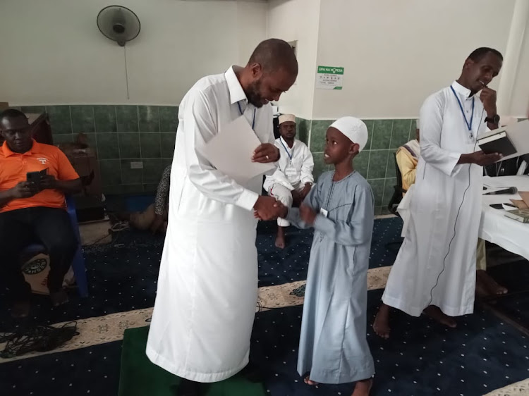 Hass charitable Trust regional coordinator Abdi Jamaa awards one of the winners in the quran competition held in Kisumu on April 8, 2023/Faith Matete