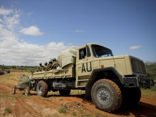 Ugandan soldiers serving African Union Mission in Somalia (AMISOM) sit in the back of a truck mounted with an anti-aircraft gun as they pass over open ground on outskirts of Afgoye, west of Mogadishu, May 24, 2012. Photo/FILE