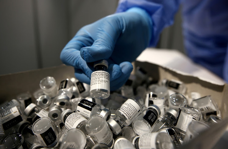 A nurse puts a used Pfizer-BioNTech Covid-19 vaccine vial in a disposal box with empty vials at Messe Wien Congress Center, which has been set up as a coronavirus disease (COVID-19) vaccination centre, in Vienna, Austria.