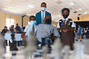 From left, chess students Iliso Mdashe, Bongolwethu Ncethelo and Elam Mdashe pose with coach Sidwell Mayekiso at the chess tournament.