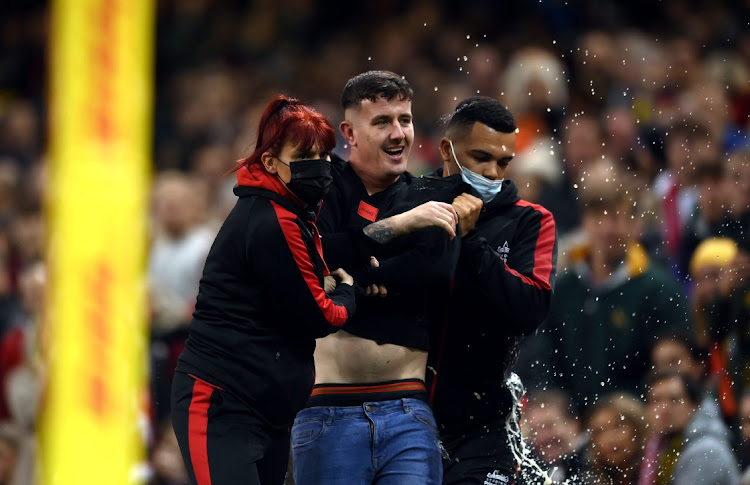 A pitch invader is ejected from the field of play during the Test Wales and SA at Principality Stadium on November 6, 2021 in Cardiff