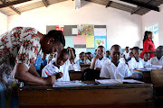 Grade 2 teacher Hlengiwe Mabaso at Inkonkoni Primary School in Umlazi marks work by Banele Masinga, 7, and Thabo Malunga, 7, on Wednesday.