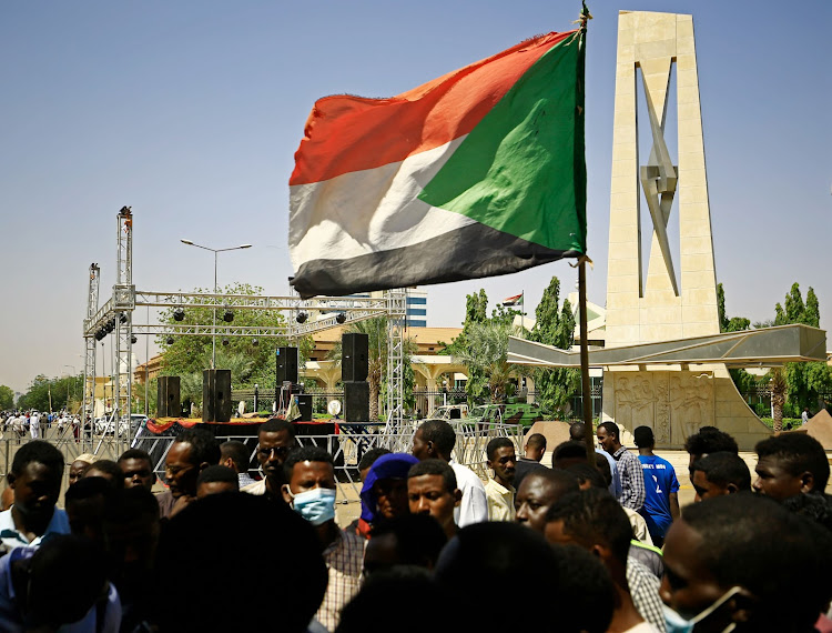 A protester holds a national flag during a sit-in demanding the dissolution of Sudan's post-dictatorship interim government, outside the presidential palace in central Khartoum on October 18, 2021.