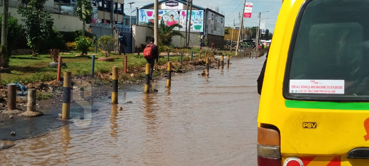 A pedestrian passes through a flooded pavement on a section of a road along LungaLunga, Industrial area following heavy rains that pounded the city last night. March 25, 2024