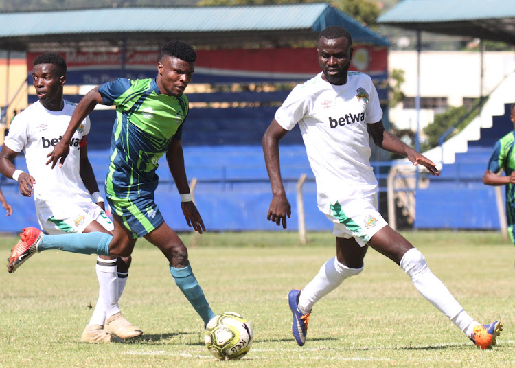 KCB’s Simon Munala tries to race past Samuel Olwande of Kariobangi Sharks