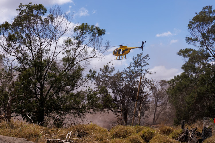 A firefighting helicopter helps fight flare-up fires in Kula, Maui island, Hawaii, US, August 13, 2023.