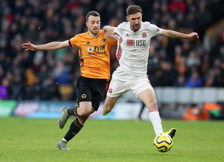 Sheffield United's Chris Basham in action with Wolverhampton Wanderers' Diogo Jota