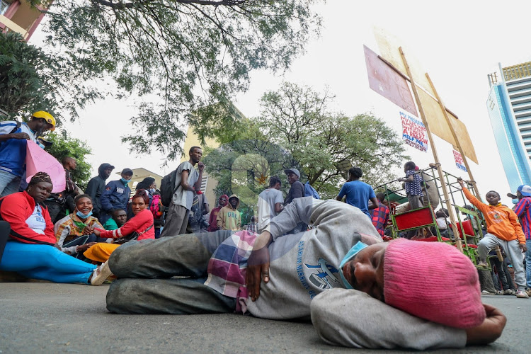 A man lie a protest outside the State Law office and department of Justice along Harambee Avenue Nairobi during the annual Saba Saba protest on July 7, 2022.