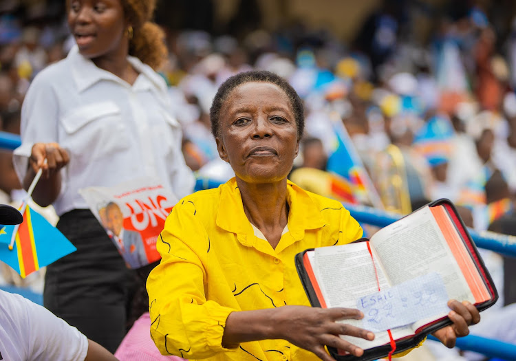 A woman holds a Bible during President Felix Tshisekedi's inauguration on January 20, 2024.