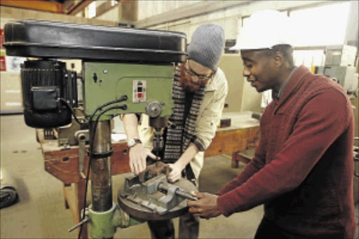 MIRACLE MAKER: Christaphor Berry and Refilwe Lediga with their machine that they claim can build houses Photo: Vathiswa Ruselo