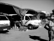 GOING NOWHERE: : A stranded woman at the Thulamahashe taxi rank walks away from the taxis after failing to travel to Gauteng owing to tension between two taxi associations. Pic. Riot Hlatshwayo. 07/05/08. © Sowetan.