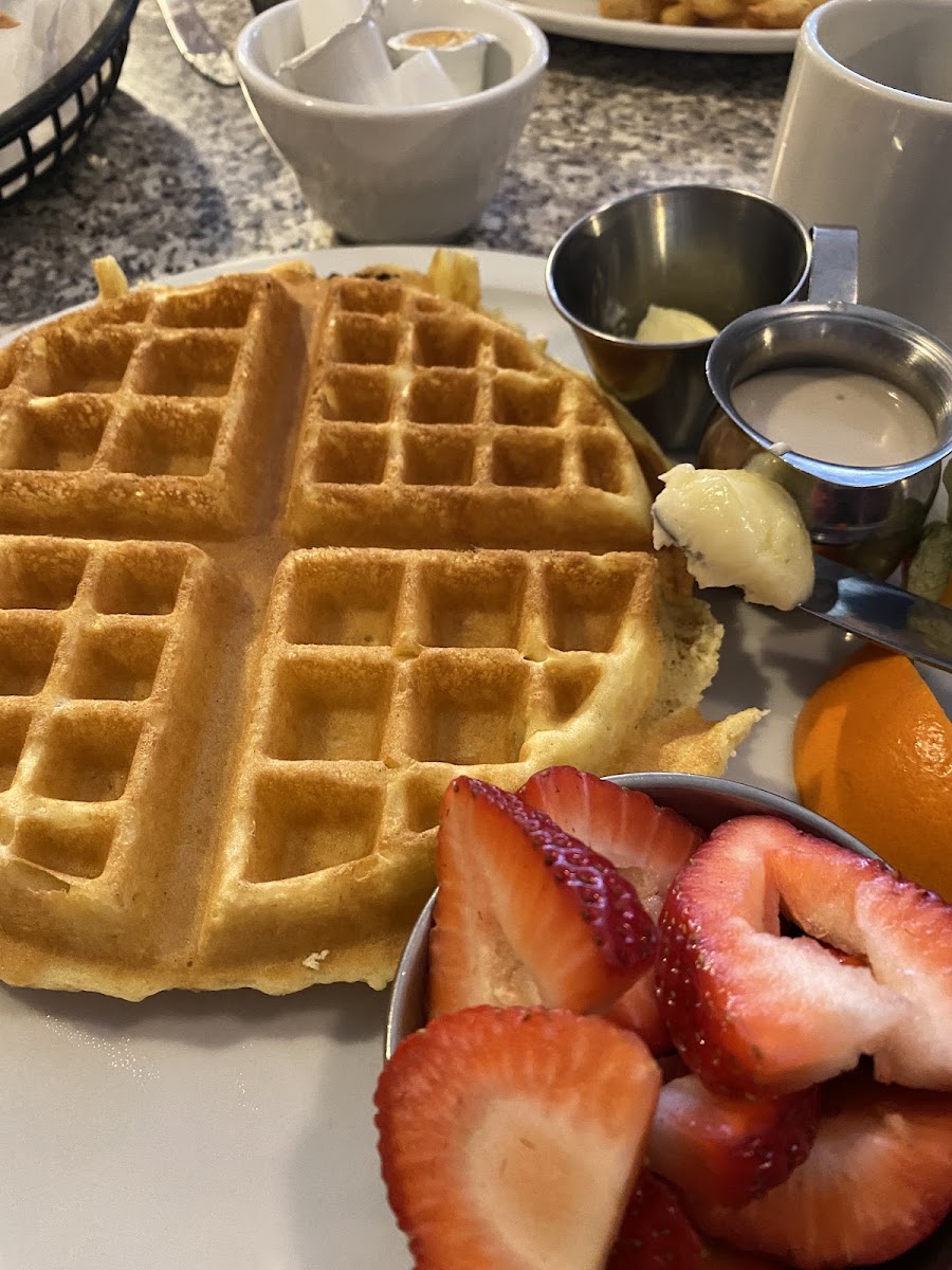 Gluten free Belgium waffle with strawberries and cream cheese syrup.