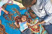 Positive dads raise bright kids.  Bulelani Futshane reads a story to little Mario.