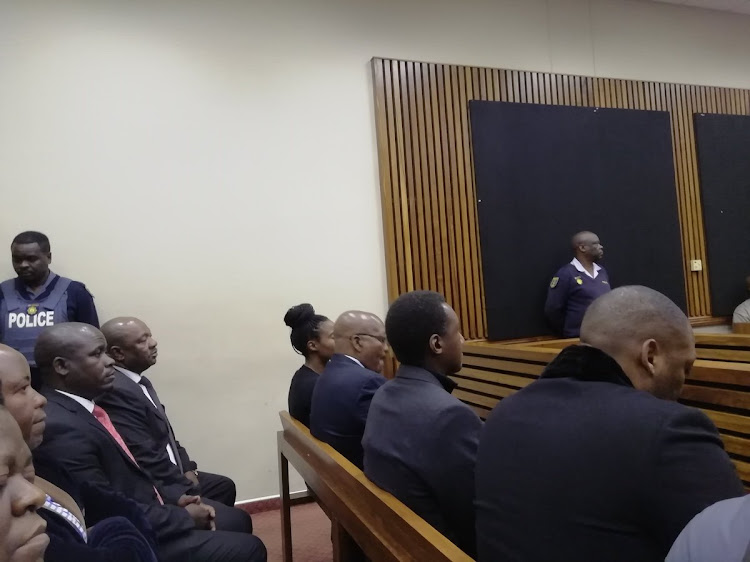 Former president Jacob Zuma (front, second from left, wearing spectacles) awaits the verdict in the culpable homicide trial of his son Duduzane Zuma.