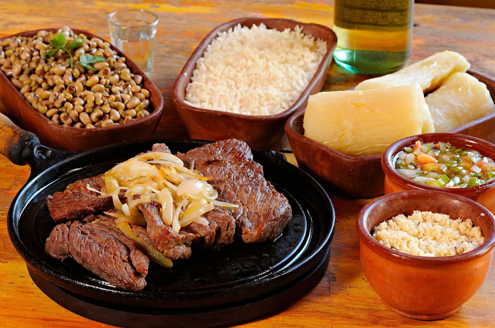 Carne de sol acebolada, prato típico de pernambuco, servida com farofa, vinagrete, macaxeira cozida, arroz e feijão.