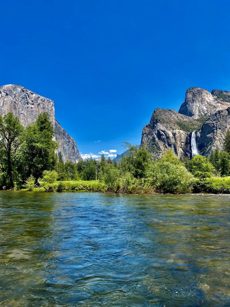 A river with trees and mountains in the background

Description automatically generated