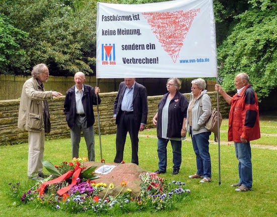 Gedenkende auf dem Friedhof. Transparent mit VVN-Logo: «Faschismuis ist keine Meinung, sondern ein Verbrechen».