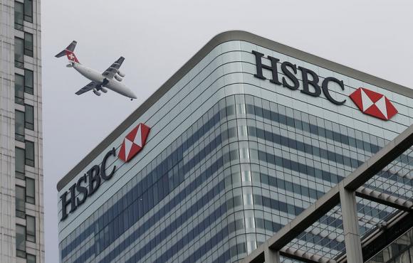 A Swiss International aircraft flies past the HSBC headquarters building in the Canary Wharf financial district in east London February 15, 2015. REUTERS/Peter Nicholls