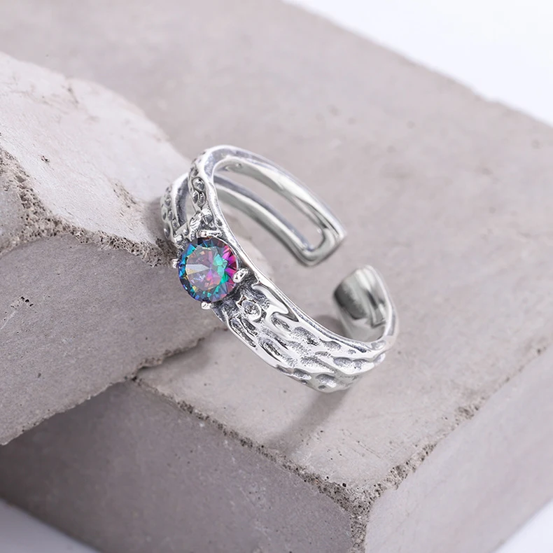 Bague en argent sterling 925 avec zirconiums colorés, motif ajouré et texture irrégulière. Un bijou unique et raffiné.