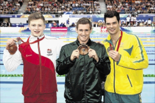 PUSHED HARD: Gold medallist Cameron van der Burgh, centre, of Team SA poses with silver medallist Adam Peaty, left, and bronze medallist Christian Sprenger after the medal ceremony for the men's 50m breaststroke finalPhoto: Quinn Rooney/Getty Images