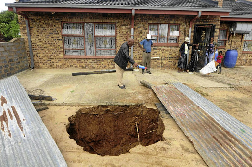 The Ngoako family are living with the danger of a sinkhole in their yard in Ngobi, North West. The sinkhole was discovered by five-year-old Otlotleng two weeks ago./Thulani Mbele