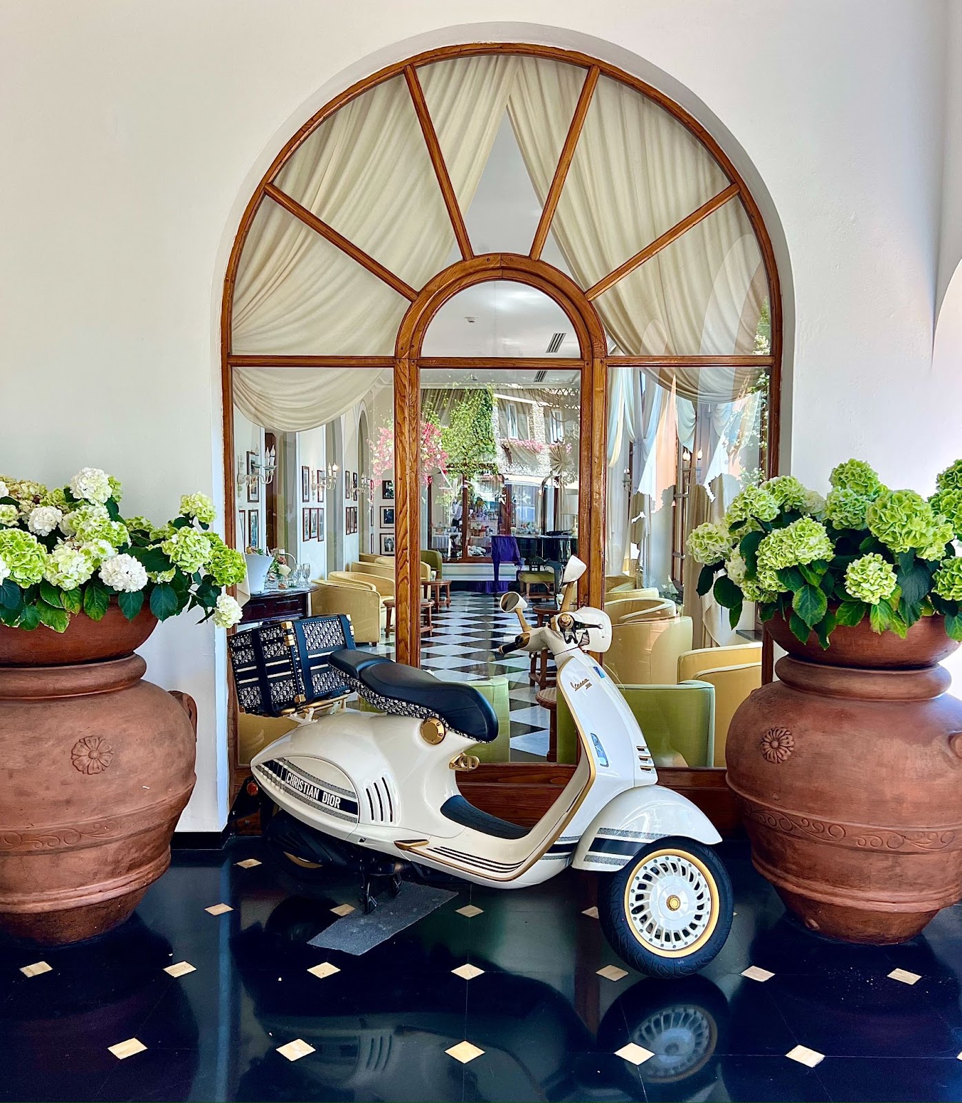 a scooter in a room with large vases and plants