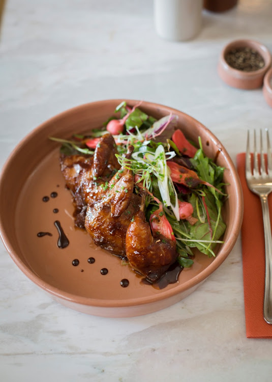 Quail dish with a sweet soy reduction and served with fresh greens and pickled radish.