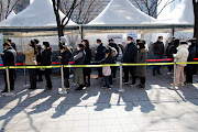 People wait in line to undergo the coronavirus disease (Covid-19) test at a temporary testing site set up at City Hall Plaza in Seoul, South Korea, February 10, 2022.   