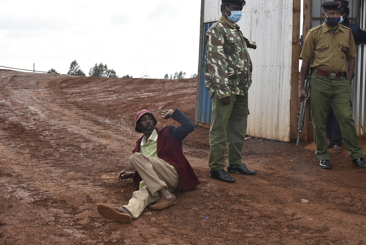 Vincent Muigai lies at the entrance to the project's site in Kariua village, Gatundu North, on Tuesday.