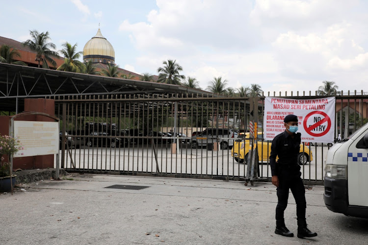 A police officer wearing protective mask stands guard outside the Seri Petaling Mosque, which has emerged as a source of hundreds of new coronavirus disease infections spanning across Southeast Asia, in Kuala Lumpur, Malaysia March 18, 2020.