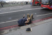 A woman assists an injured person after an attack on Westminster Bridge in London, March 22, 2017.  Four people were killed when 52-year-old Khalid Masood drove a car into pedestrians on the pavement. 