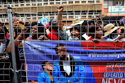 Supporters of Shepherd Bushiri hold a banner of the self-proclaimed prophet and his wife Mary outside the court.