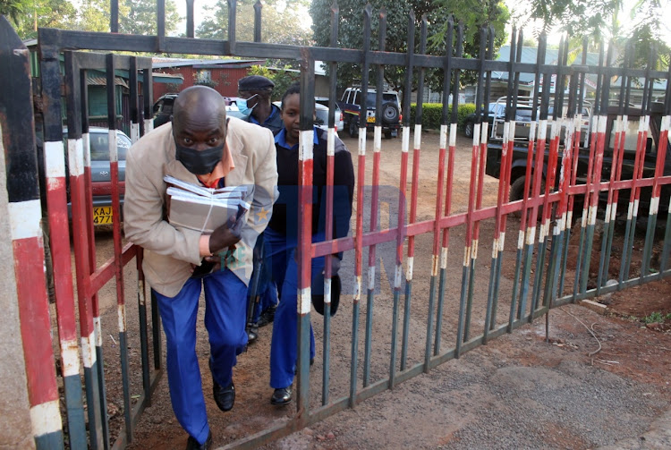 A teacher holds KCPE mathematics exam papers at Westlands DCC's office on March 7, 2022.