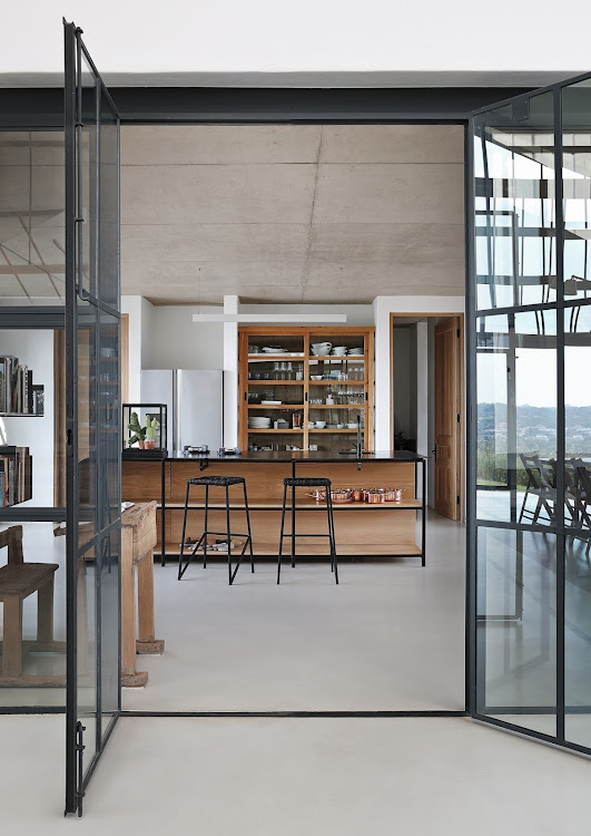 The central conservatory opens onto a kitchen; here the concrete ceiling has been left exposed, honestly expressing its materiality.