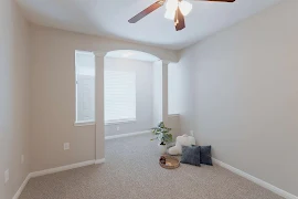 Bedroom with sunroom area, crown molding, light beige carpet and walls, white trim, and a window